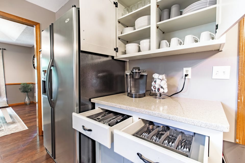 The kitchen is stocked with essential utensils and cookware, making it ideal for preparing meals and drinks. The open layout allows for easy interaction with guests while cooking.