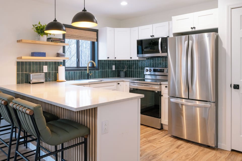 New kitchen with counter stools—experience the comforts of home in the woods, with all the modern amenities you need.