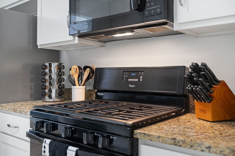 Modern gas range and fully stocked cooking essentials..