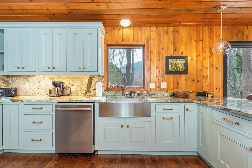 Kitchen with gas range, double oven, dishwasher, drip-style coffee maker, and breakfast bar seating for 3