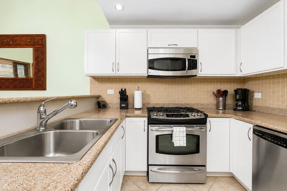 Fully equipped kitchen featuring modern appliances, cookware, essentials, and ample space for meal preparation.