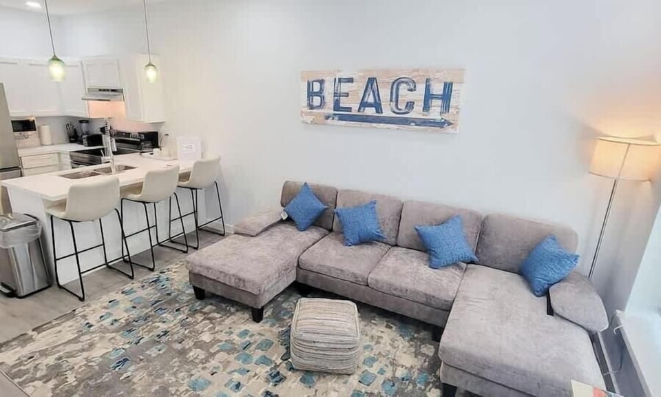 A bright, relaxed living space where soft coastal touches and clean lines create an easy flow. The open layout and gentle tones bring a calm rhythm to the room, offering a comfortable place to unwind and settle into a naturally unhurried stay.