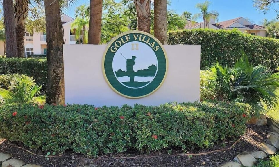 Golf Villas community entrance sign surrounded by tropical landscaping.