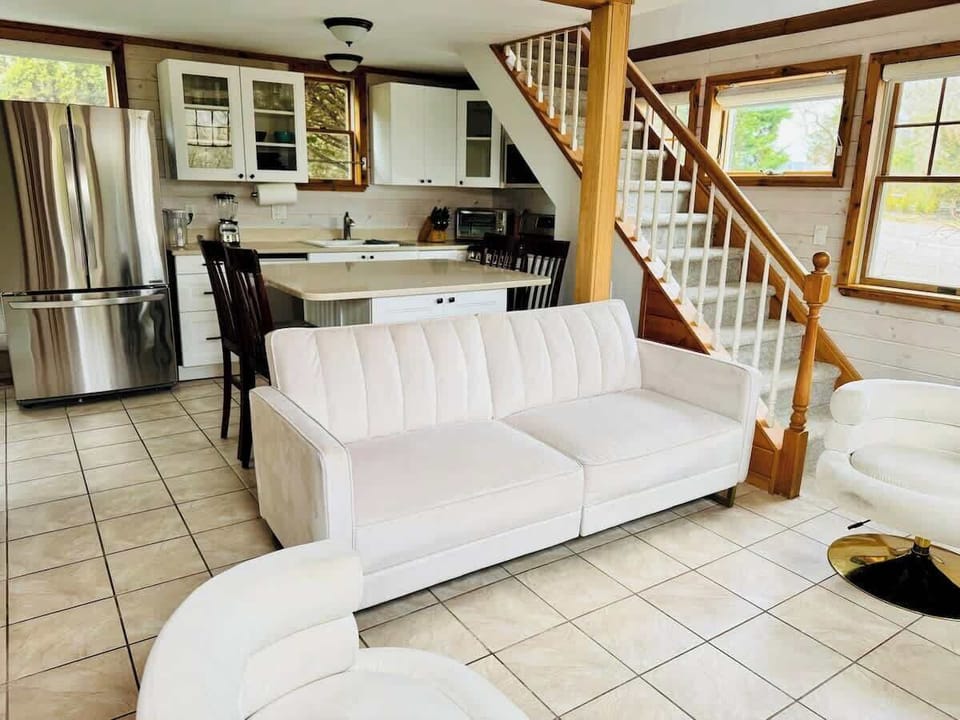 Kitchen, dining table and living room featuring a comfortable sofa bed.