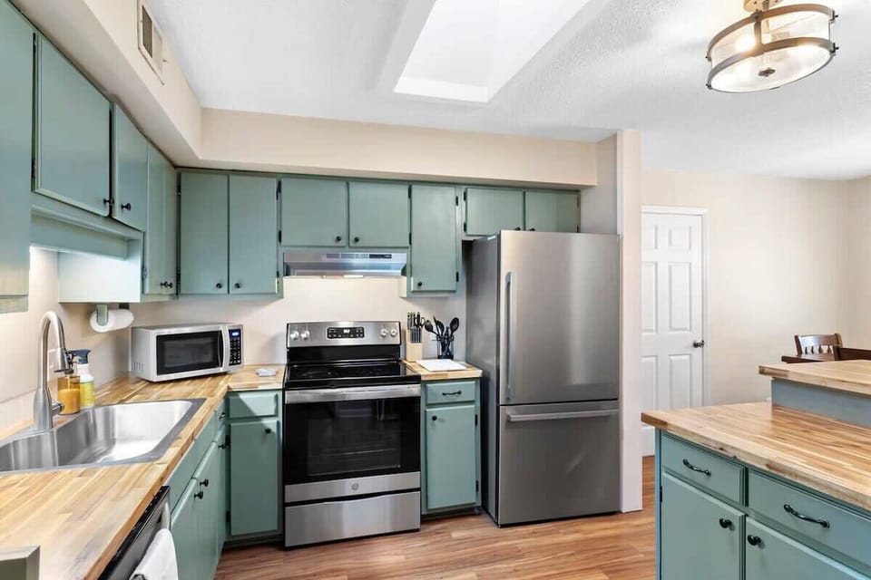 Well designed kitchen with modern finishes, wood counters, and plenty of storage. Bright and welcoming, perfect for preparing meals and gathering together.