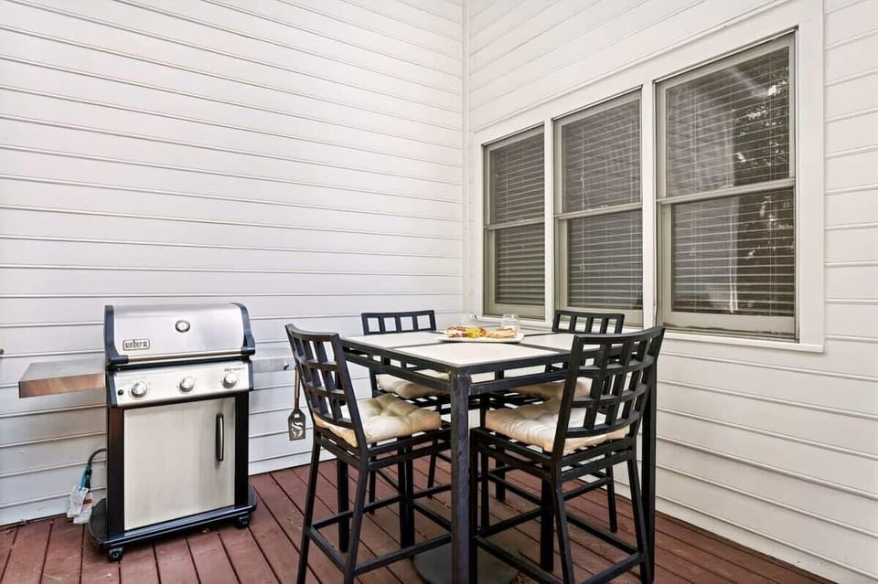 Charming private back porch with a dining table and grill, offering a comfortable spot to enjoy fresh air and outdoor meals during your stay.
