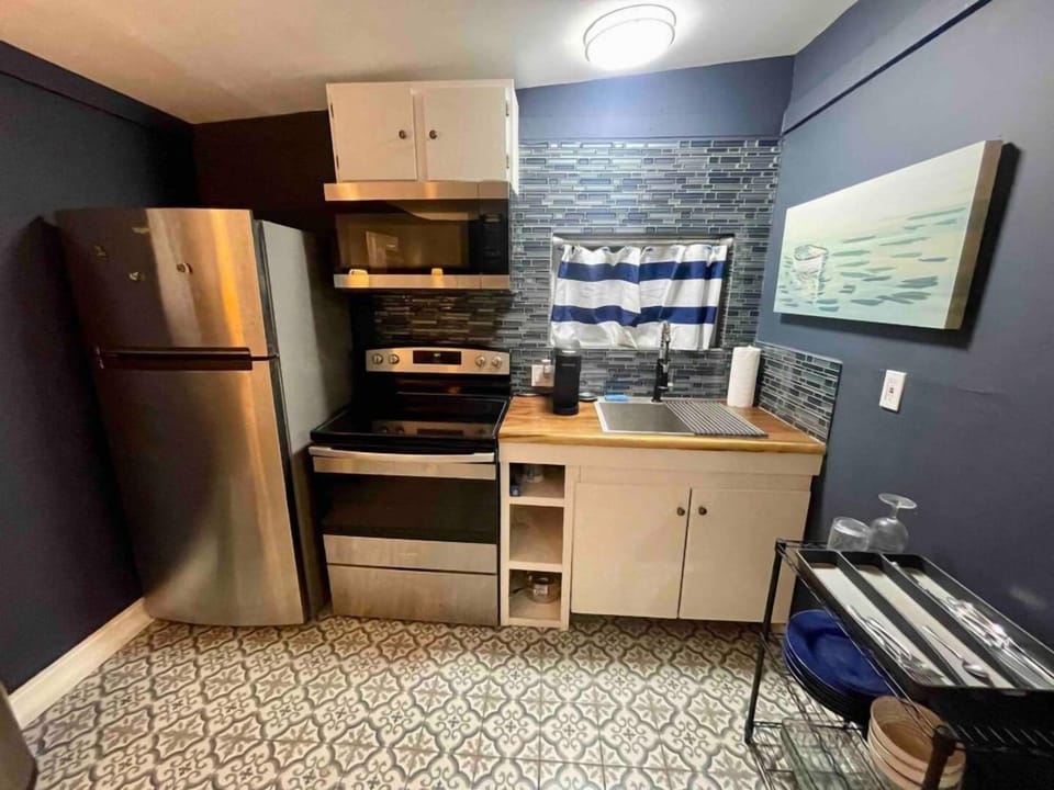 Stainless appliances full sized fridge and electric oven.