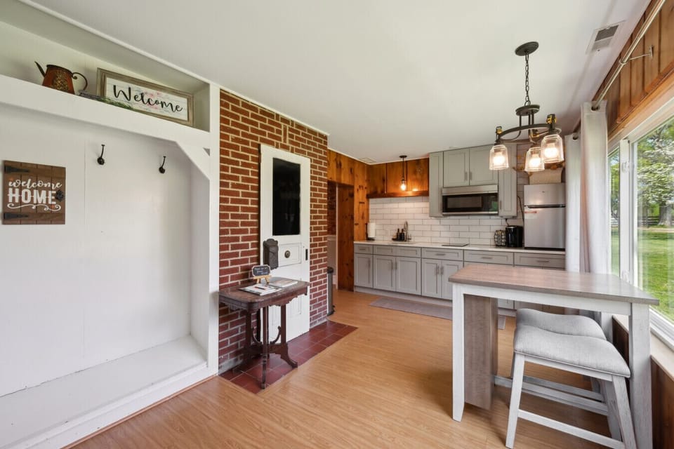 Stylish kitchen w/ brick accents, peninsula seating & open flow to dining area