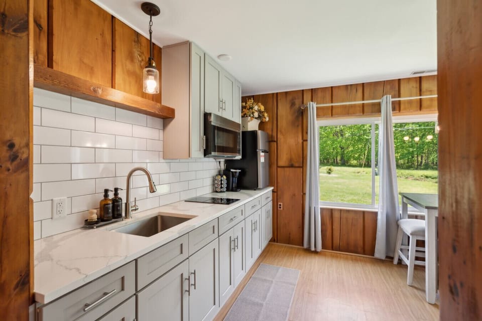 Galley-style kitchen w/ subway tile backsplash & views of the backyard