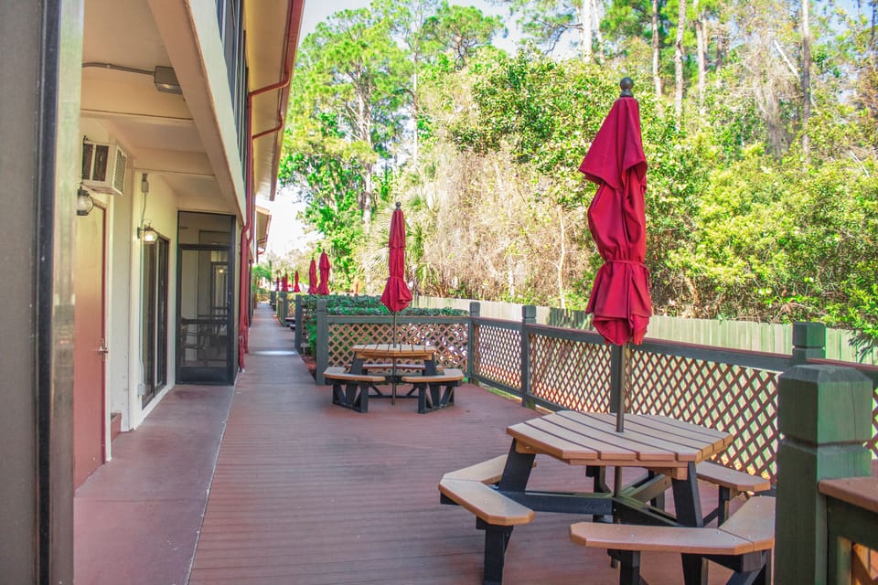 Sip morning coffee outdoors at shaded picnic tables.