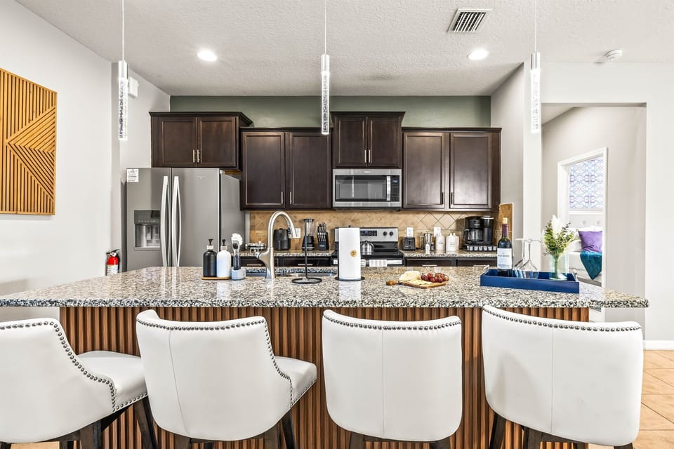 The kitchen island has 4 chairs for additional dining.