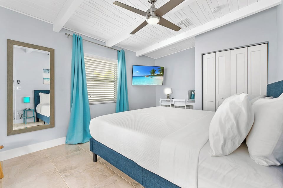 Serene king bedroom with Smart TV & workspace. Relax in beachy bliss.
