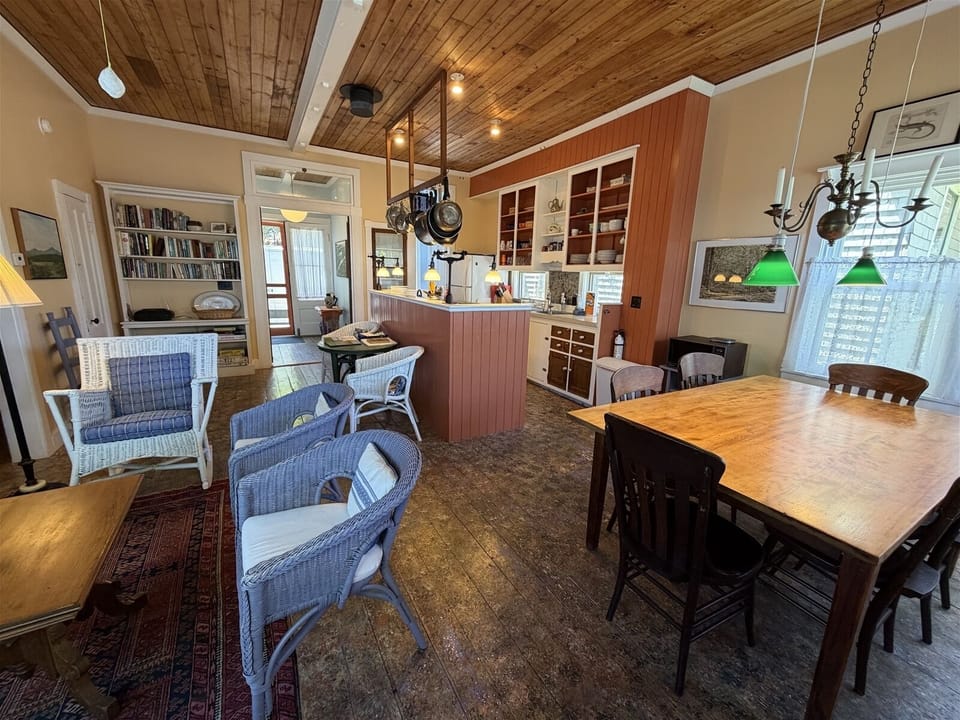 Enter in the cottage and you are greeted by the large living area with high ceilings including a kitchen, sitting area with TV, Dining area, and full bath