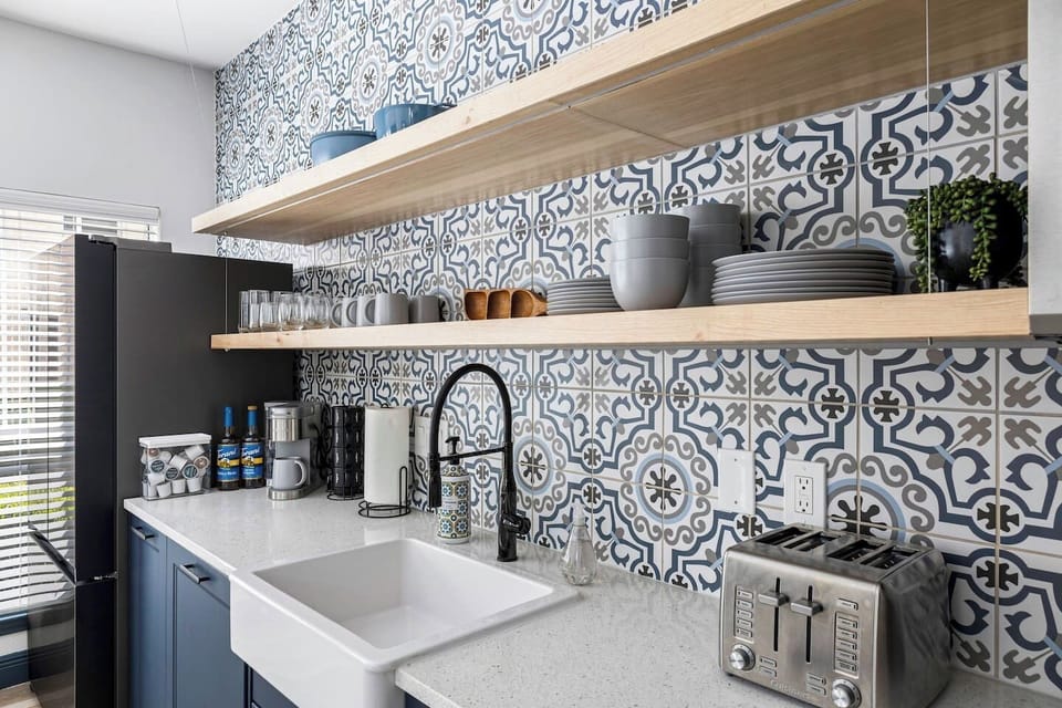 Stocked kitchen with clean & organized dinnerware set, cups, toaster, & farmhouse sink