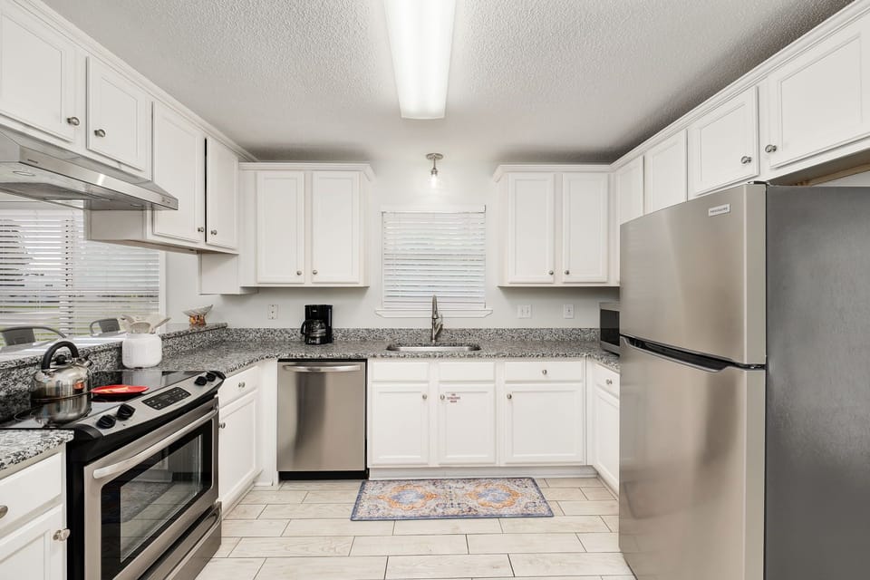 Beautiful kitchen with crisp white cabinetry and granite countertops.