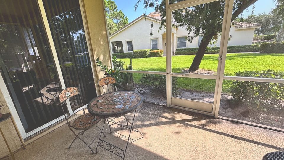 Enjoy true Florida-style indoor-outdoor living! This fully screened-in patio features a charming mosaic bistro set—perfect for sipping your morning coffee.