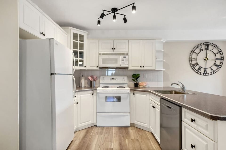 Full kitchen with a blender, drip coffee maker, ground coffee, tea, and sugar.