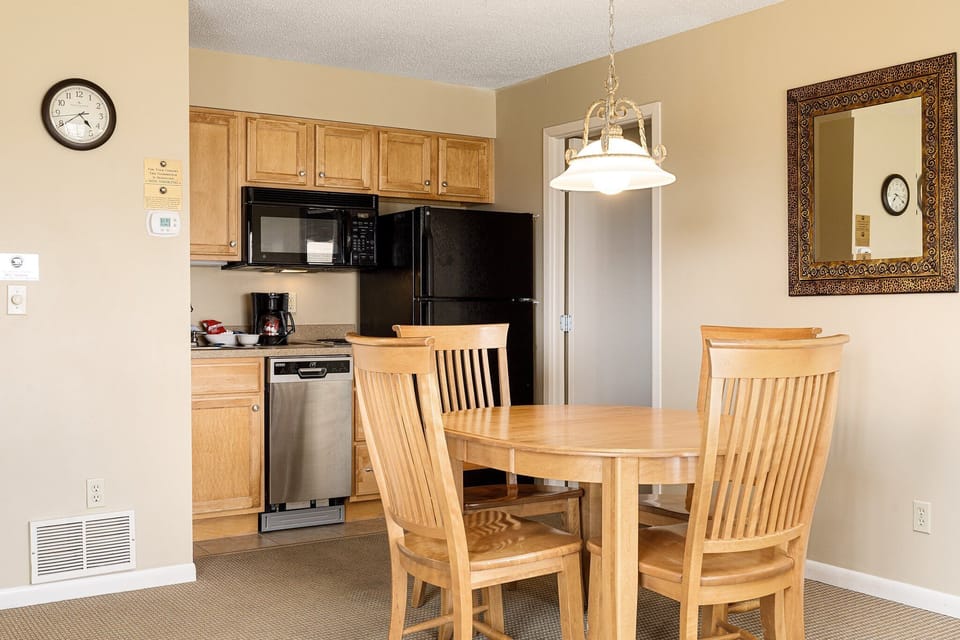 Dining table for four beside a fully equipped kitchen for easy meals at home.