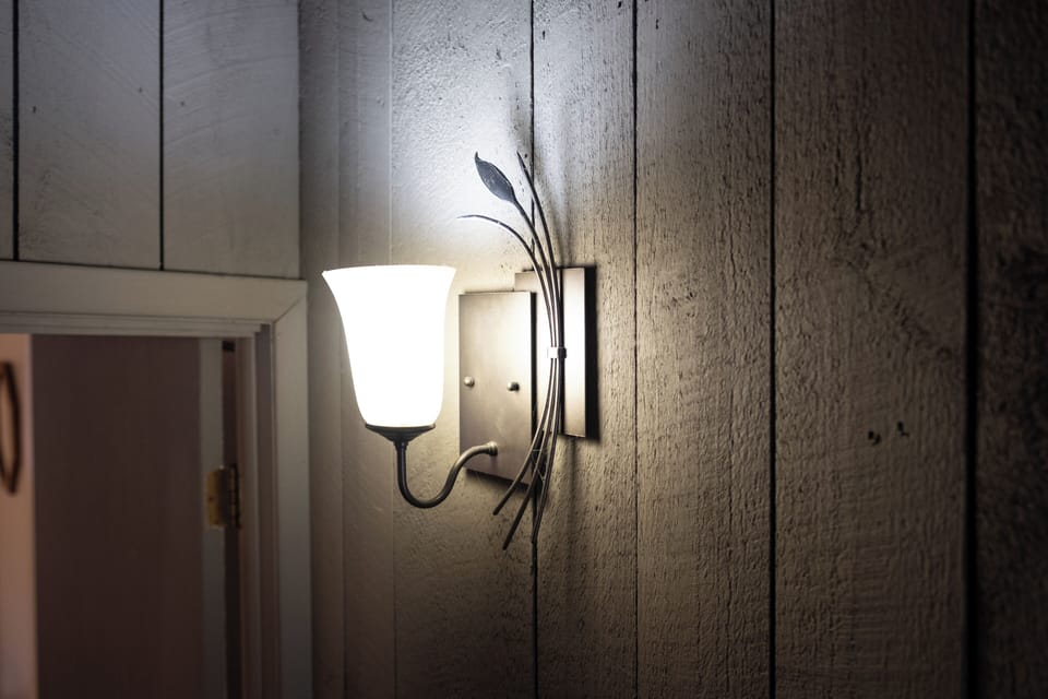 - Warm wall sconce lighting adds cozy cabin ambiance   - Unique detail enhances rustic Vermont mountain style   - Creates a welcoming glow in the evening hours