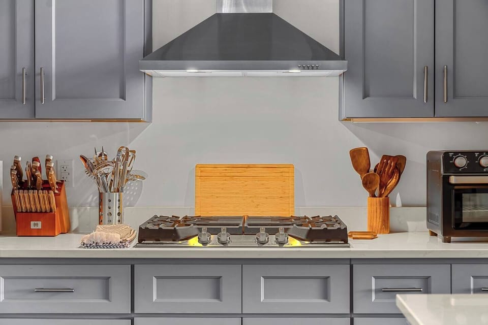 Gas range with butcher's block, air fryer, and cooking utensils. 