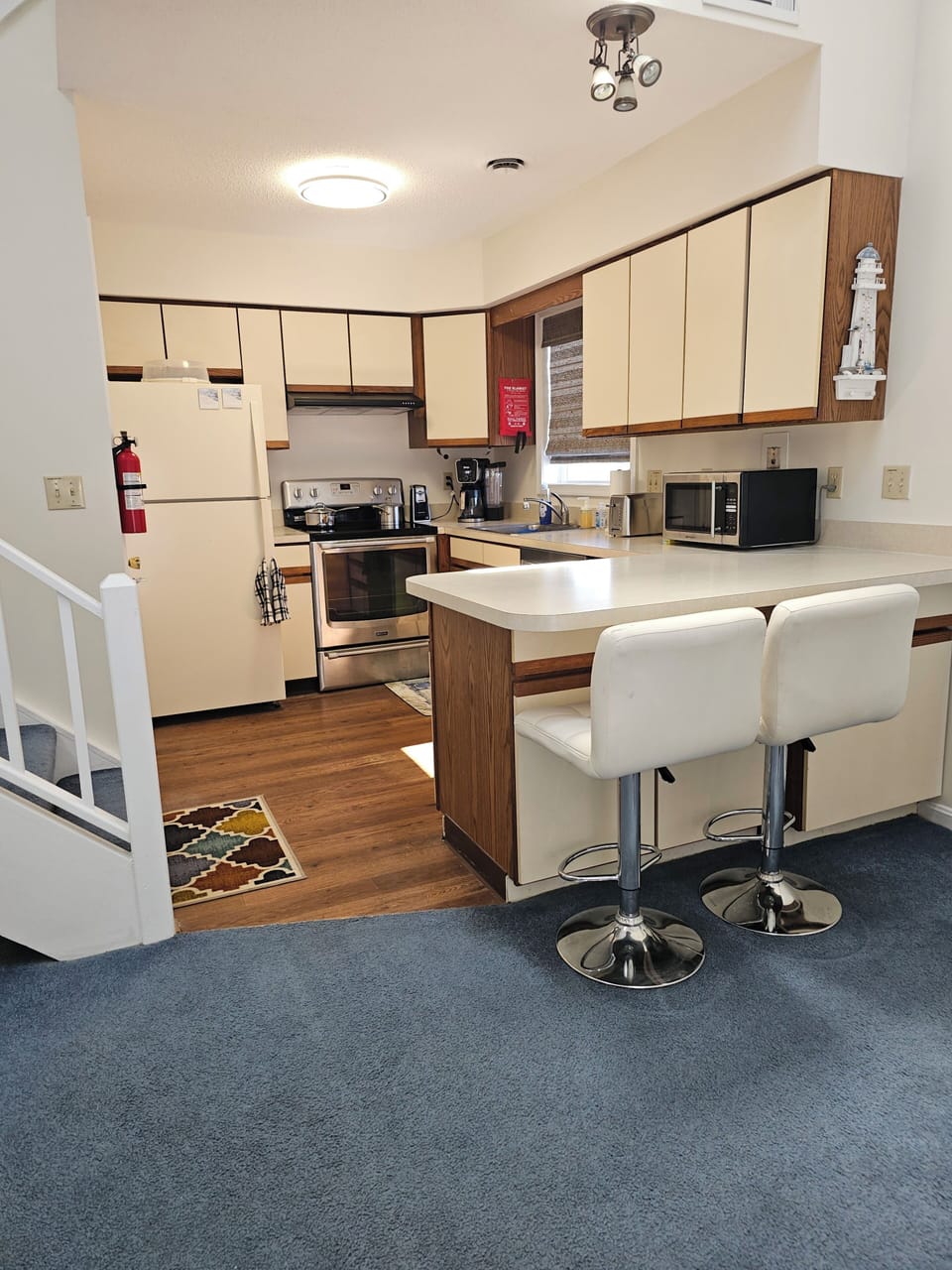 Large kitchen with dishwasher, oven, refrigerator, coffee maker, microwave.