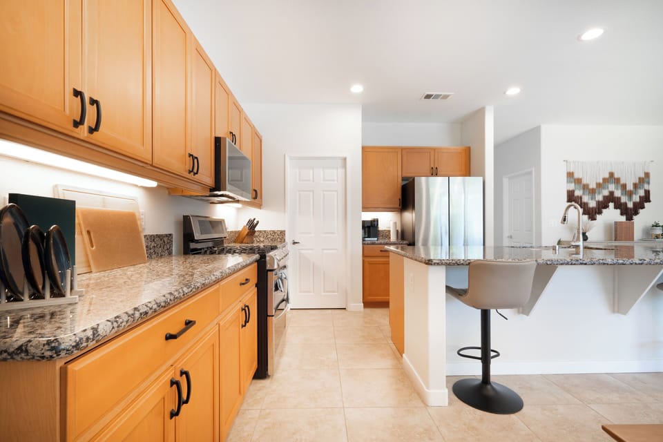 Fully stocked kitchen with stainless steel appliances.