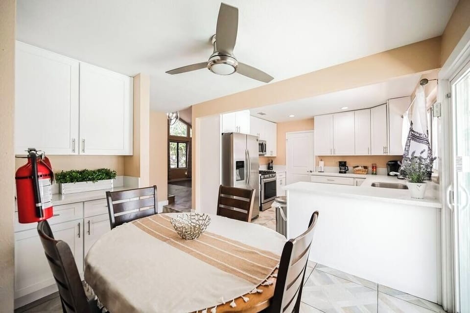Modern kitchen with white cabinetry and stainless steel appliances.