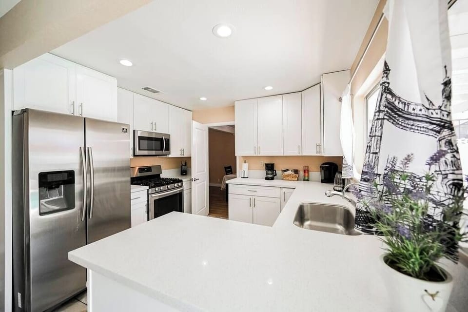 Modern kitchen with white cabinetry and stainless steel appliances.