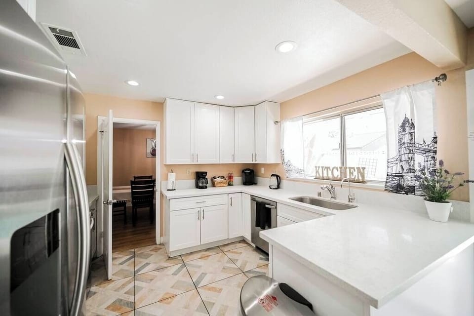 Modern kitchen with white cabinetry and stainless steel appliances.