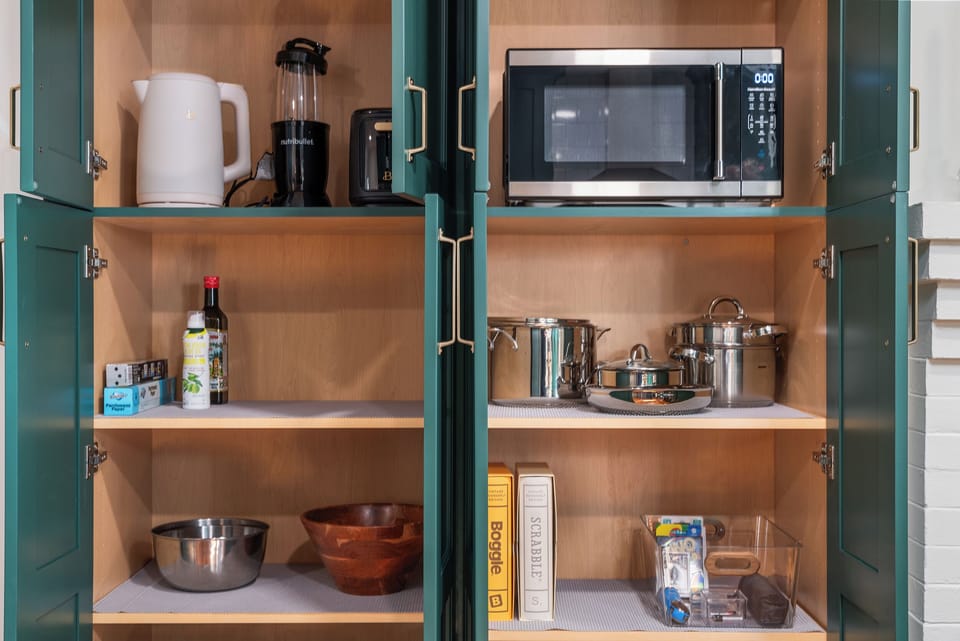 Organized kitchen with cookware, appliances & essentials for a home-like stay.