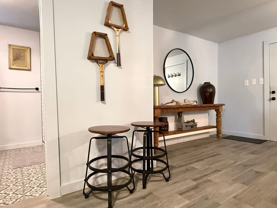 Warm, welcoming corner with rustic décor and bar stools — a cozy space to relax or plan your next OKC adventure.