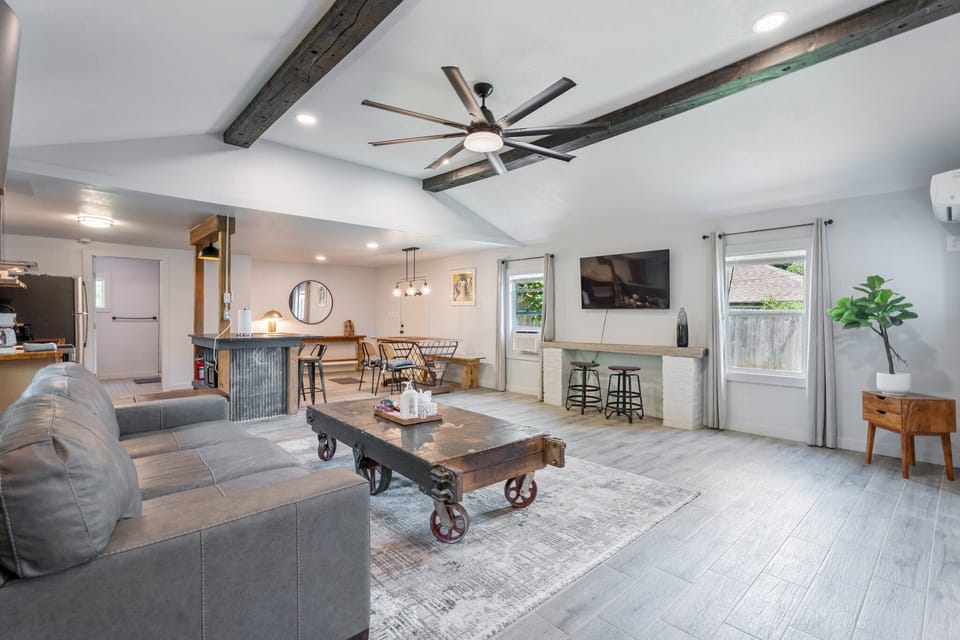 Stylish industrial coffee table, plush seating, and bar counter workspace—form meets function in this airy, modern space.