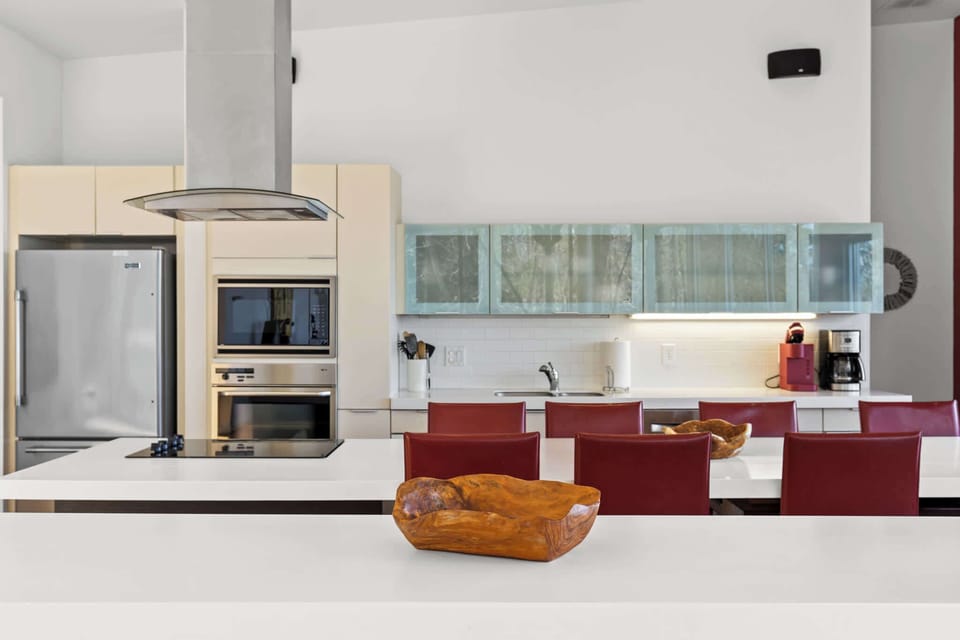 Our fully stocked kitchen boasts high-end appliances and a spacious island that seamlessly combines dining and prep space. 