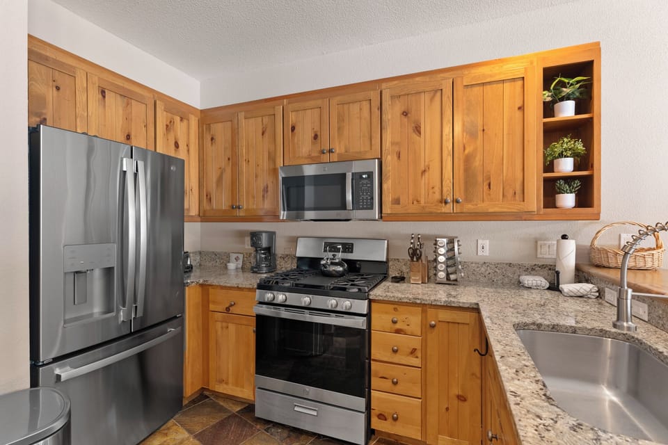 Your fully equipped kitchen features warm knotty pine cabinetry, granite countertops, stainless steel appliances, and a gas range—everything you need to prepare delicious home-cooked meals during your stay.