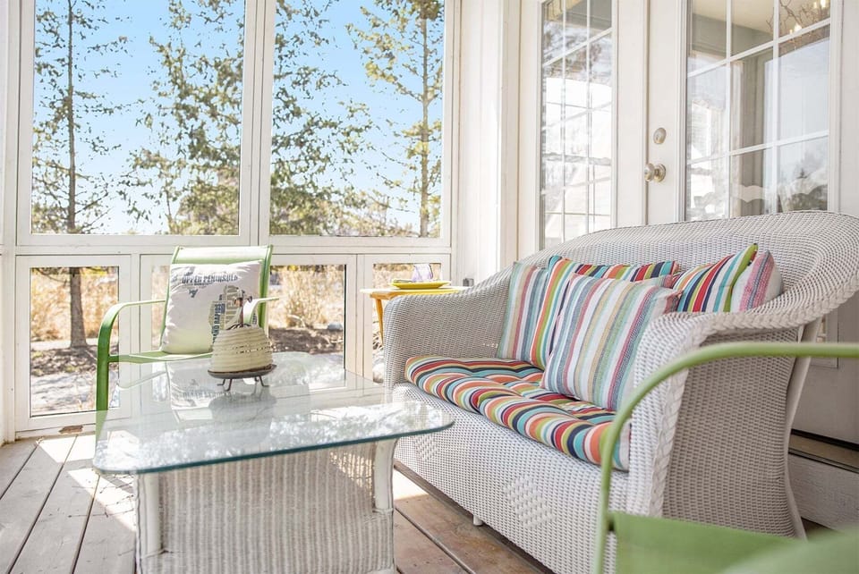 Beautiful screen porch spans the front of the home to relax in the breeze