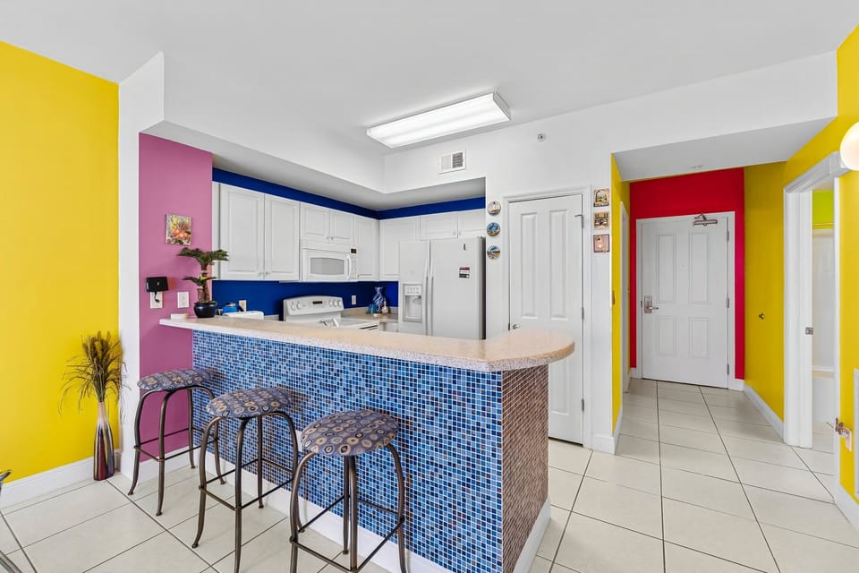 Colorful kitchen with a tiled breakfast bar and modern appliances