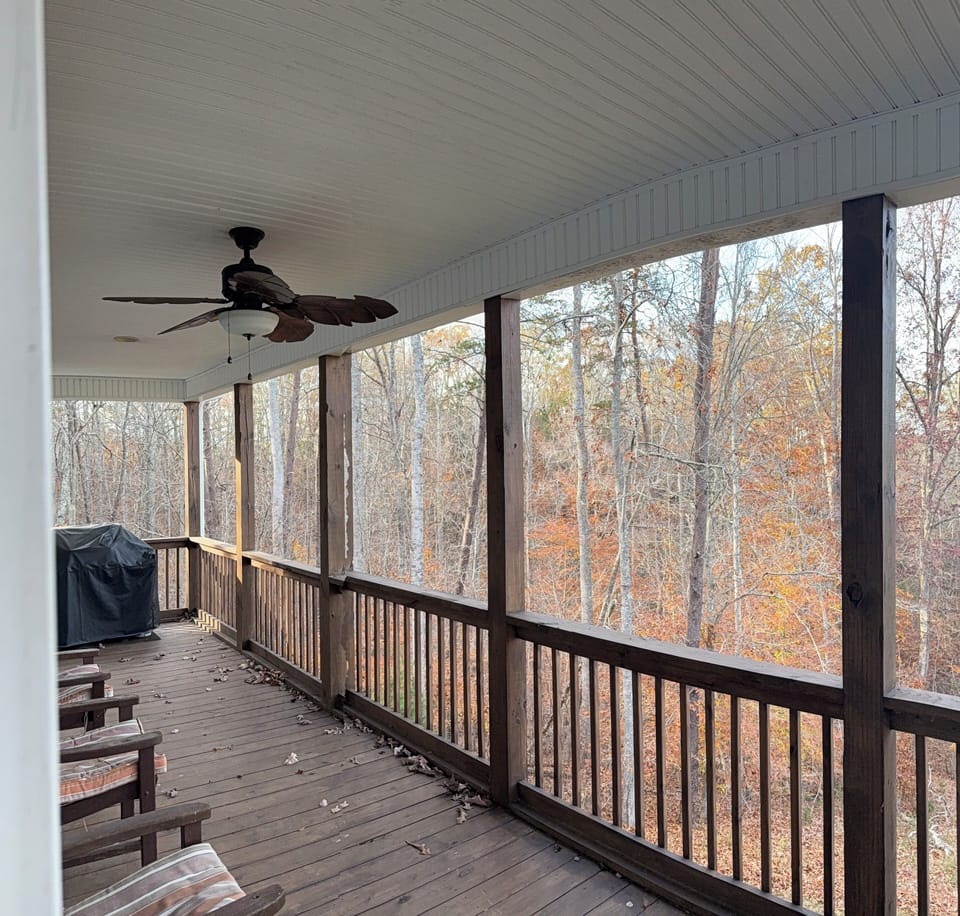 Covered back deck with grill and seating.