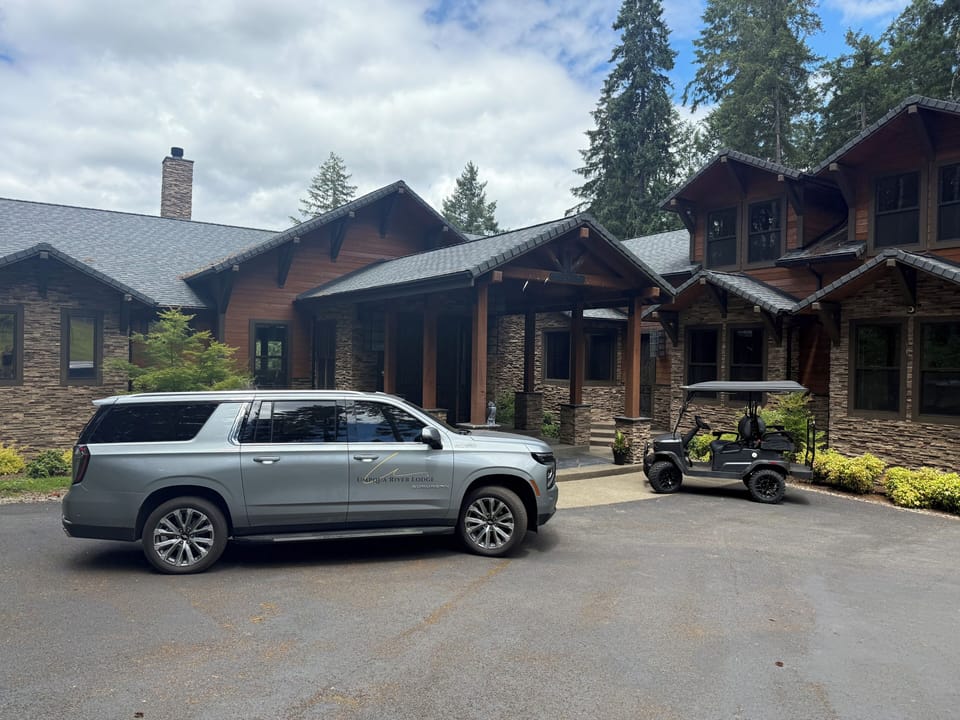 Front of lodge with wine tour Suburban and lodge guests golf cart “Maverick”.
