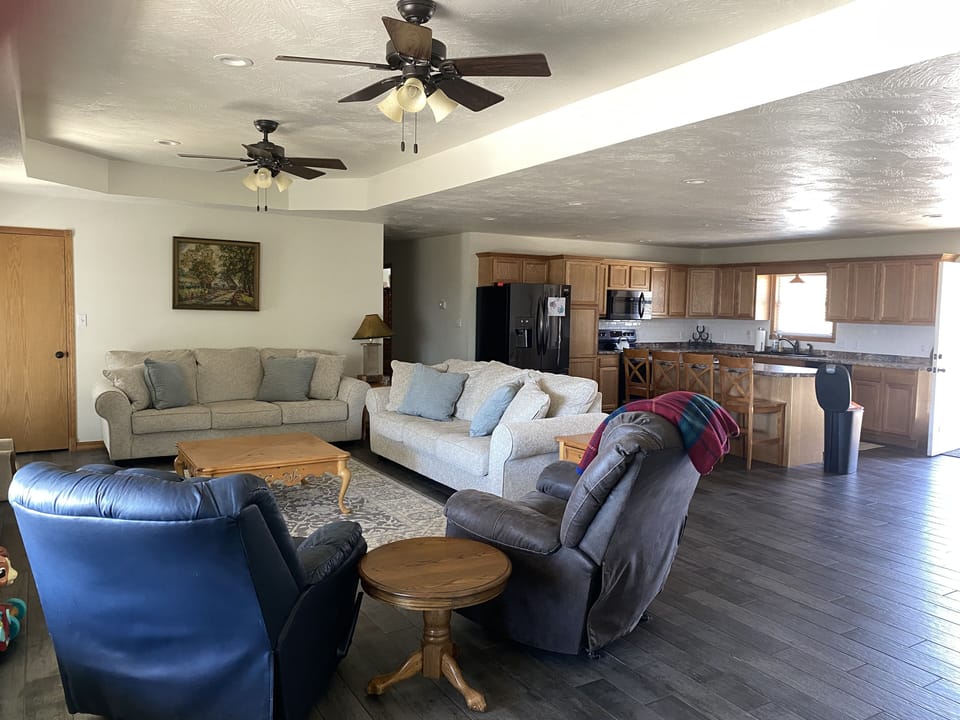 Open concept kitchen/living room with large TV and electric fireplace. 