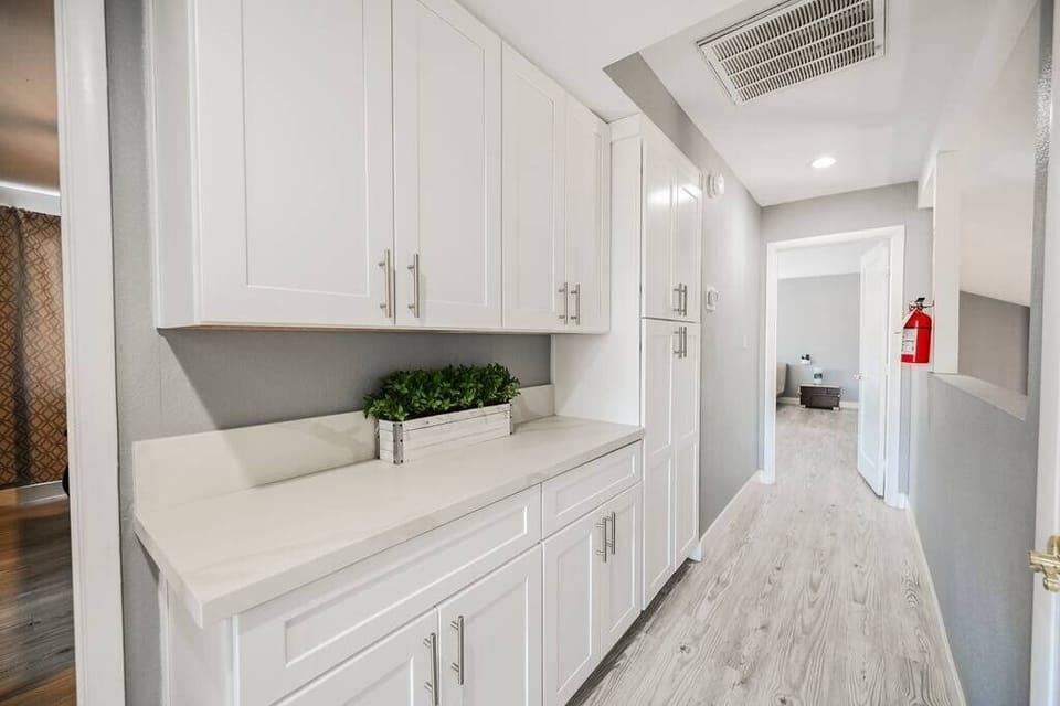 A bright and organized laundry room with sleek white cabinetry