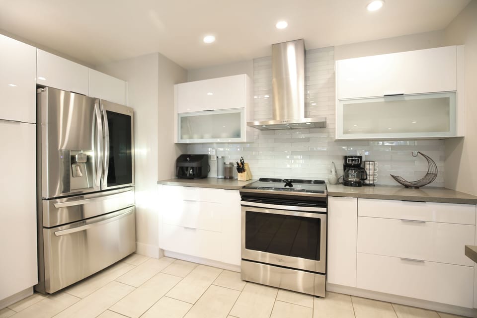 Sleek stainless steel appliances and a full set of pots and pans.