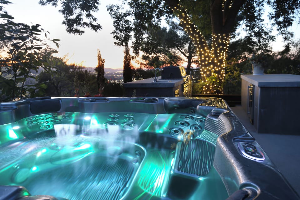 A spacious hot tub that seats seven takes center stage on the backyard patio.