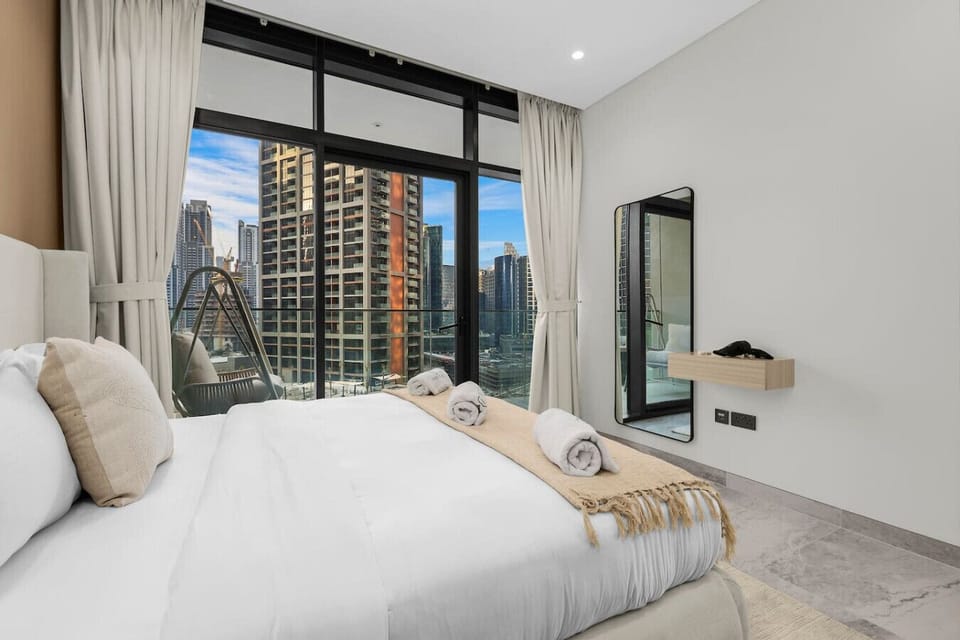 Stylish Bedroom: Relax in luxury with skyline views and modern decor for a perfect getaway!