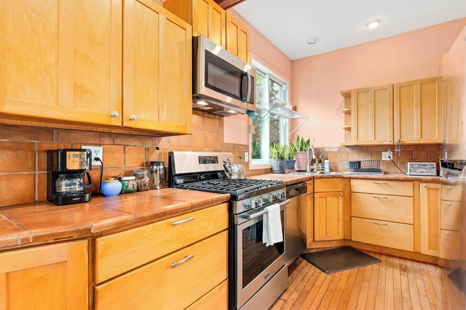 Fully equipped and filled with light, the kitchen opens to the backyard for easy outdoor dining.