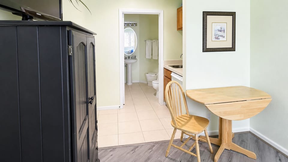 Functional in-room kitchenette and dining area with easy access to the bathroom.