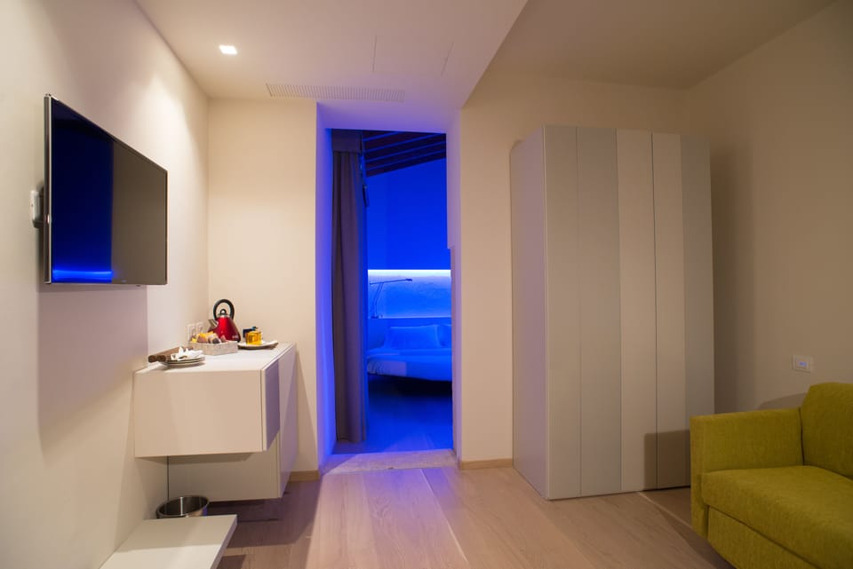 Design Quadruple Room, 1 Bedroom | Living area | Flat-screen TV