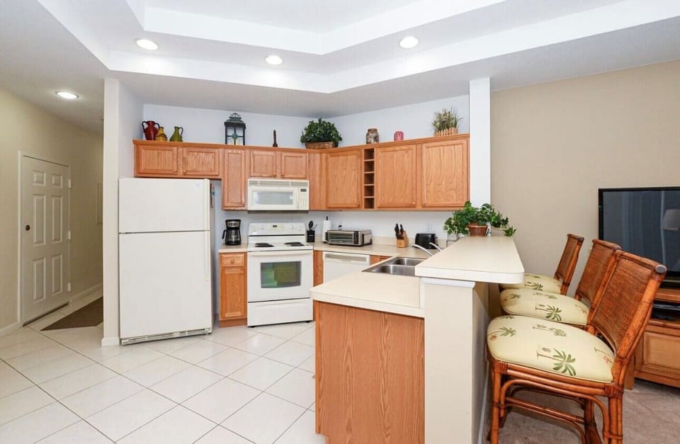 Bright kitchen and dining area featuring full-size appliances, breakfast bar seating, and an open flow into the living space.