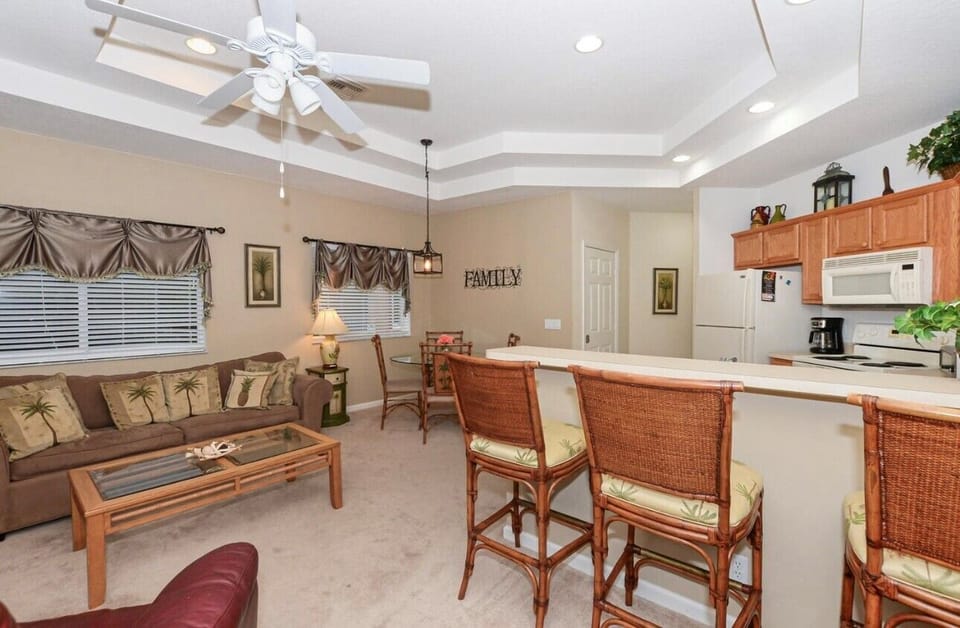 Open-concept living and dining area with high ceilings, comfortable seating, and a bright, welcoming layout.