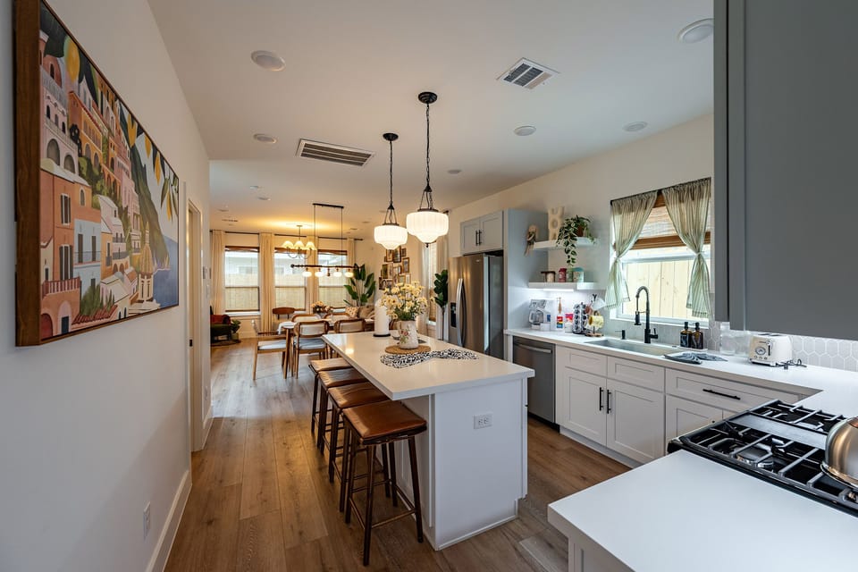 Spacious kitchen and dining with pendant lights and island seating.