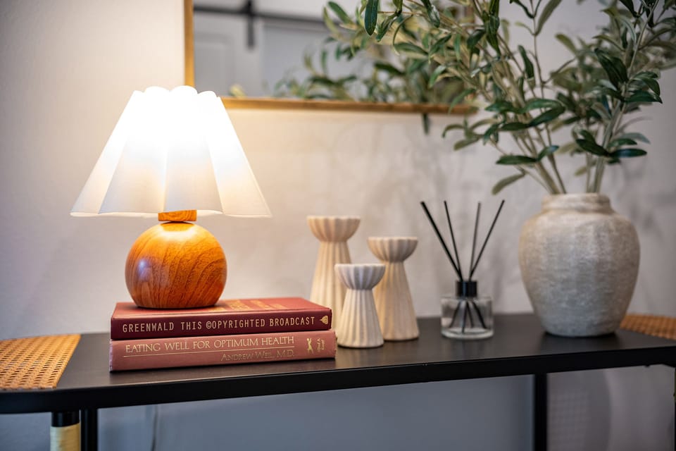 Entry table with reed diffuser, lamp, and soft lighting.